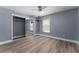 Bedroom featuring wood-look flooring, ceiling fan, window and closet with mirrored doors at 404 N Sundance Dr, Lake Mary, FL 32746