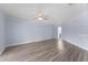 Spacious bedroom with sleek plank flooring, modern ceiling fan, and a doorway to an en-suite bath at 404 N Sundance Dr, Lake Mary, FL 32746