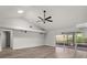 Bright living room features vaulted ceiling, ceiling fan, wood flooring, and sliding doors at 404 N Sundance Dr, Lake Mary, FL 32746
