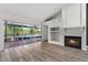 Living area showcasing a brick floor patio view, wood floors, and built-in shelves and fireplace at 404 N Sundance Dr, Lake Mary, FL 32746