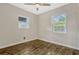 Cozy bedroom featuring a ceiling fan, natural light from two windows, and hardwood flooring at 407 S Lakemont Ave, Winter Park, FL 32792