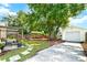 Expansive backyard featuring a hammock, patio seating, a garage, mature trees, and a stone path at 415 Florida Ave, St Cloud, FL 34769