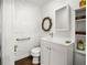 Compact bathroom featuring white vanity with sink, toilet, mirror, and textured walls at 415 Florida Ave, St Cloud, FL 34769