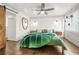 Bright bedroom with hardwood floors, white walls, a ceiling fan, and a green leaf-patterned blanket at 415 Florida Ave, St Cloud, FL 34769
