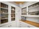 Spacious pantry featuring glass front cabinets, butcher block countertops, and storage for appliances and goods at 415 Florida Ave, St Cloud, FL 34769