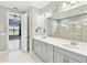 Bright bathroom featuring a double sink vanity, white countertops, and a glass-enclosed shower with neutral tile at 433 Via Abruzzi St, Kissimmee, FL 34759