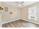 Small bedroom with hardwood floors, a ceiling fan, and a window with curtain and white trim at 433 Via Abruzzi St, Kissimmee, FL 34759