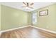 Bedroom with green walls, wood floors, white trim, a ceiling fan, and a window with blinds at 433 Via Abruzzi St, Kissimmee, FL 34759