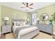 Bedroom featuring green walls, hardwood floors, white trim, and blue accents with white bedding at 433 Via Abruzzi St, Kissimmee, FL 34759