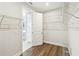Walk-in closet featuring built-in metal shelving and wood floors located next to the Primary bathroom at 433 Via Abruzzi St, Kissimmee, FL 34759