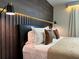 Cozy bedroom highlighting contemporary lighting fixtures and a dark wood paneled headboard at 4473 Kaipo Rd, Davenport, FL 33897