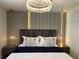 Elegant bedroom featuring a striking chandelier and sleek wall panels with ambient lighting at 4473 Kaipo Rd, Davenport, FL 33897