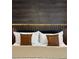 Beautiful bedroom featuring sleek wood-look accent wall with under-lighting, soft linens, and two leather pillows at 4473 Kaipo Rd, Davenport, FL 33897