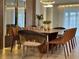 A bright and airy dining room featuring a modern wood table with unique chairs and stylish pendant lighting at 4473 Kaipo Rd, Davenport, FL 33897