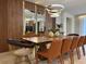 Elegant dining room with a long wooden table, stylish chairs, and modern lighting fixture at 4473 Kaipo Rd, Davenport, FL 33897