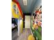 Hallway featuring unique cartoon character murals, custom-built playhouse design, and wood floors at 4473 Kaipo Rd, Davenport, FL 33897