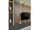 Living room with sleek entertainment center, modern wood paneling, and ambient lighting, showcasing contemporary design at 4473 Kaipo Rd, Davenport, FL 33897