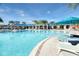 Resort style pool with lounge chairs, palm trees and colorful umbrellas create a relaxing outdoor oasis at 4473 Kaipo Rd, Davenport, FL 33897