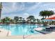 Resort style pool with lounge chairs, palm trees and colorful sun umbrellas create a relaxing outdoor oasis at 4473 Kaipo Rd, Davenport, FL 33897