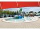 Community splash pad area with colorful water features, lounge chairs and shaded seating at 4473 Kaipo Rd, Davenport, FL 33897