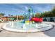 Community splash pad area with colorful water features, lounge chairs and shaded seating at 4473 Kaipo Rd, Davenport, FL 33897
