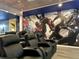 Home theater featuring comfortable leather recliners and a large Marvel-themed mural at 4473 Kaipo Rd, Davenport, FL 33897