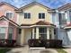 Charming yellow townhouse featuring a terra cotta roof, bay window, and well-maintained landscaping at 4726 Hemingway House St, Kissimmee, FL 34746