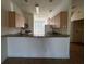Kitchen with granite countertops, light wood cabinets, and modern appliances at 4726 Hemingway House St, Kissimmee, FL 34746