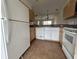 Full kitchen view with white appliances, wooden cabinets, and tile flooring at 4726 Hemingway House St, Kissimmee, FL 34746
