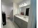 A well-lit bathroom with double sinks and a vanity with generous counter space, and a shower, and walk-in closet at 505 Peace Way, Poinciana, FL 34759