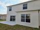A view of the back exterior showing two stories, a patio, sliding glass doors, and several windows at 511 Elbridge Pl, Kissimmee, FL 34758