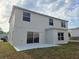 A view of the back exterior showing two stories, a patio, sliding glass doors, and several windows at 511 Elbridge Pl, Kissimmee, FL 34758