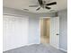 Bedroom with gray carpet, closet with bi-fold doors, and a ceiling fan with light fixture at 511 Elbridge Pl, Kissimmee, FL 34758