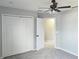 Bright bedroom featuring a ceiling fan, closet with bi-fold doors, and gray carpet at 511 Elbridge Pl, Kissimmee, FL 34758
