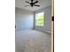 Bright bedroom with neutral walls, ceiling fan, and a large window overlooking the greenery at 511 Elbridge Pl, Kissimmee, FL 34758