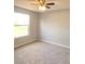 Bedroom with neutral decor, gray carpeting, ceiling fan, and a bright window at 511 Elbridge Pl, Kissimmee, FL 34758