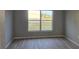 Bedroom featuring neutral gray walls, wood-look floors, and a large window at 511 Elbridge Pl, Kissimmee, FL 34758