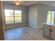 Dining area featuring gray walls, wood-look floors, and a large window with a backyard view at 511 Elbridge Pl, Kissimmee, FL 34758