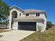 Exterior of a two-story house with two-car garage, and neutral color scheme, on a clear day at 511 Elbridge Pl, Kissimmee, FL 34758