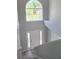 Bright foyer featuring a large arched window, hardwood floors, and a staircase with carpeted steps at 511 Elbridge Pl, Kissimmee, FL 34758