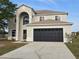 Two-story home featuring an attached two car garage, and large archway above the front door at 511 Elbridge Pl, Kissimmee, FL 34758