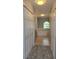 Hallway with carpet floors between two closets leading to a bathroom with a tub at 511 Elbridge Pl, Kissimmee, FL 34758