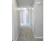 Hallway with gray carpet leading to rooms and a closet; fresh paint and bright lighting at 511 Elbridge Pl, Kissimmee, FL 34758
