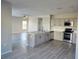 Open kitchen features stainless steel appliances, an island, and wood-look flooring at 511 Elbridge Pl, Kissimmee, FL 34758