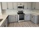 Close-up of kitchen featuring stainless appliances, gray cabinets, and quartz countertops at 511 Elbridge Pl, Kissimmee, FL 34758