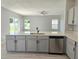 Open concept kitchen featuring a large island with sink, stainless steel appliances, and backyard view at 511 Elbridge Pl, Kissimmee, FL 34758
