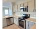Modern kitchen features stainless steel appliances, white cabinets, and quartz countertops at 511 Elbridge Pl, Kissimmee, FL 34758