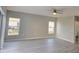 Cozy living area featuring wood-look floors, ample natural light, and open layout to kitchen at 511 Elbridge Pl, Kissimmee, FL 34758