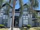 A charming, two-story condo building with palm trees and visible stairs to upper units at 5501 G Nw Ave # 4714, Orlando, FL 32815