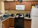 An efficient kitchen with wooden cabinets, granite countertops, and modern appliances for cooking needs at 5501 G Nw Ave # 4714, Orlando, FL 32815